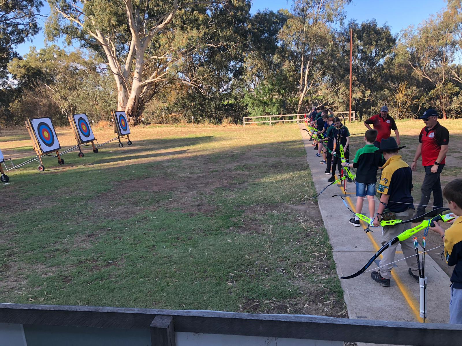 People with bows and arrows learning to shoot